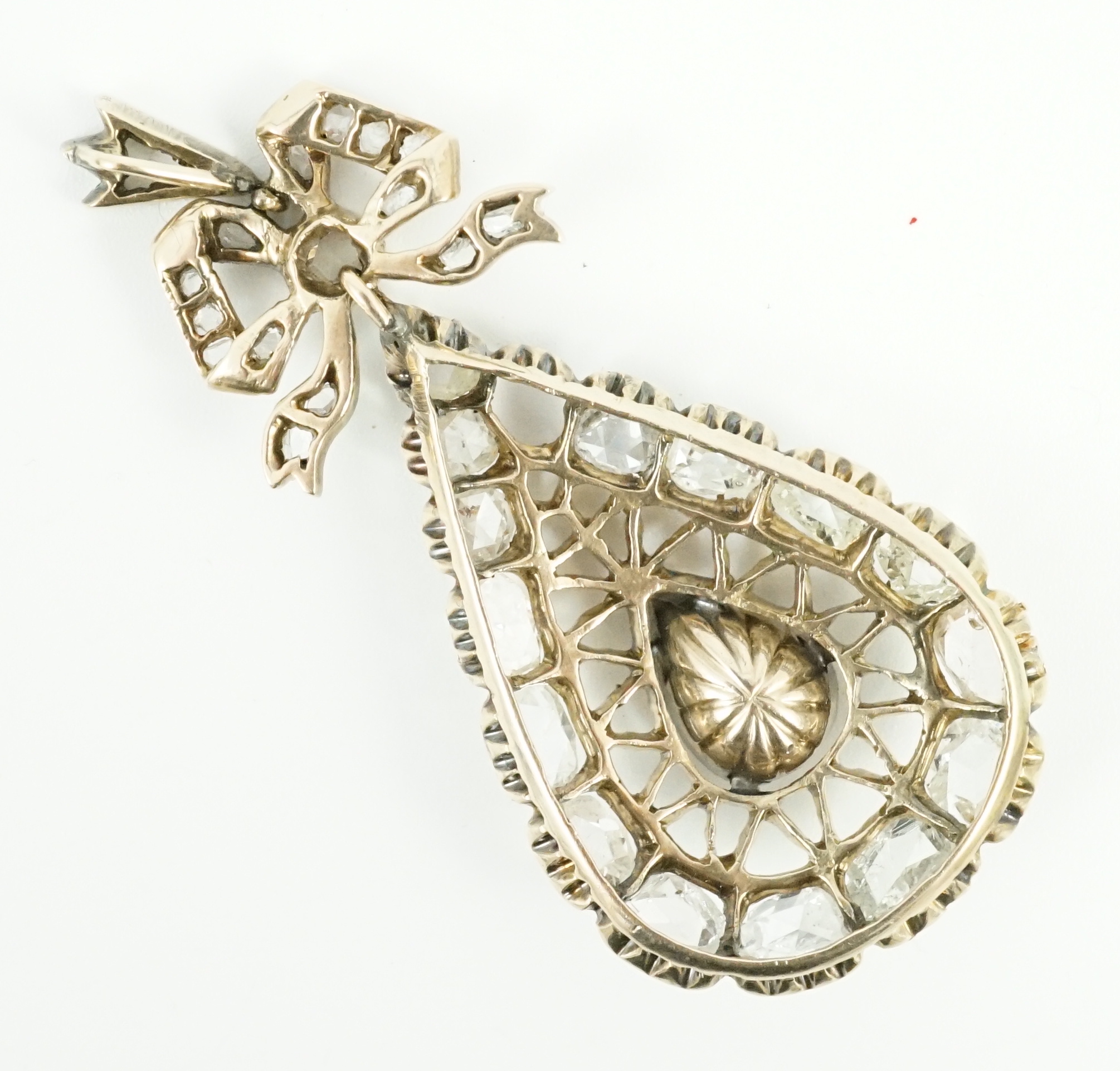 An early 19th century gold and rose cut diamond cluster set pear shaped drop pendant, with ribbon bow bale